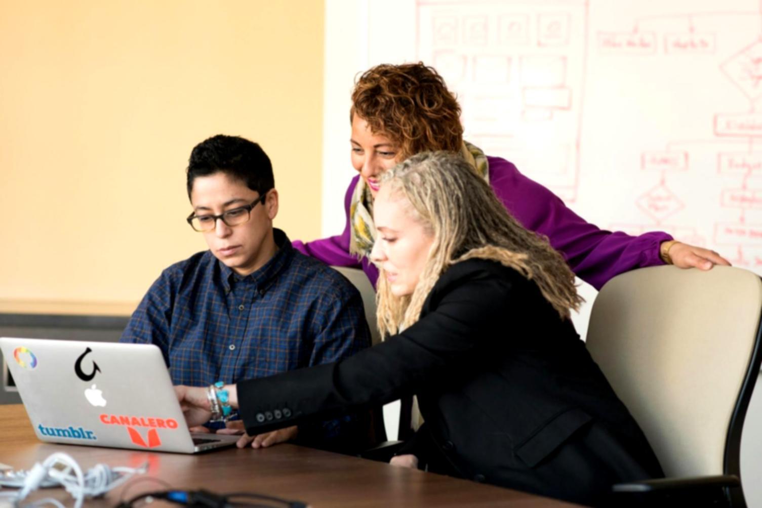 Instructor providing personalized coding guidance to student at computer workstation